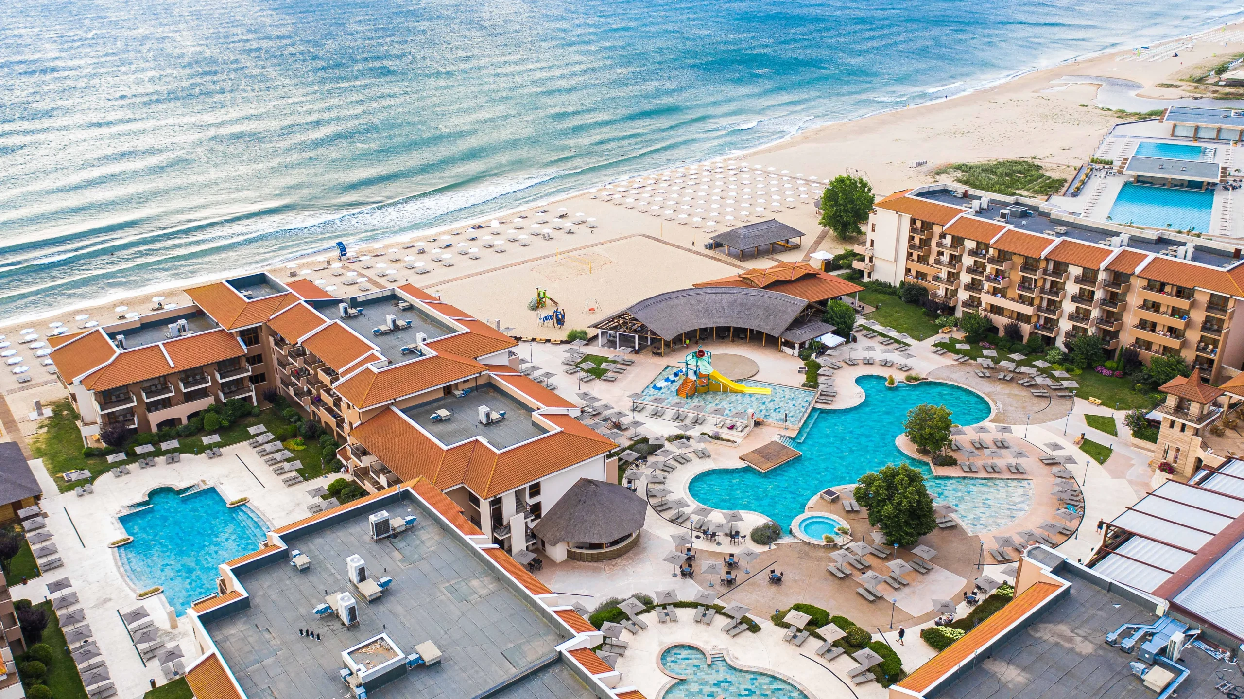 Aerial panoramic view of HVD Club Hotel Miramar resort with outdoor swimming pools and private sandy beach in Obzor